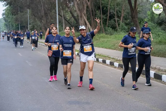 Runners waving to the camera on the tree-lined route