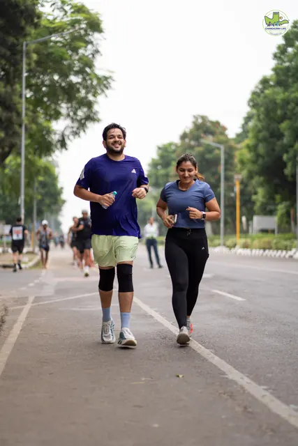 Two runners side by side on the tree-lined road