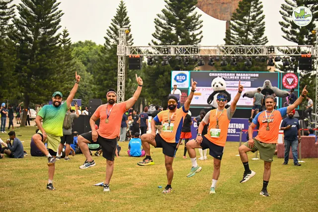 A group of runners jumping together in front of the stage