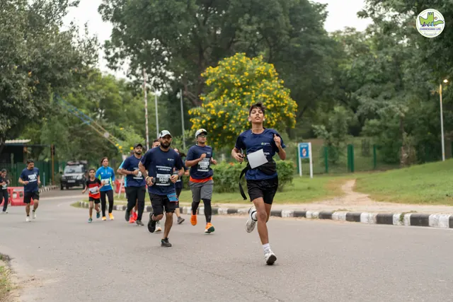 Runners coming down the road past a green hedge