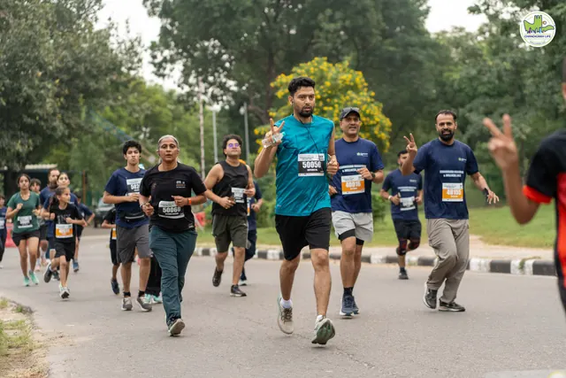A pack of runners on the road, a man in teal at the front