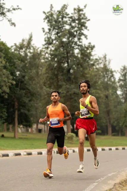 Two men running in orange and red vests