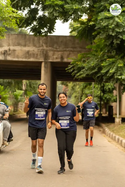 Two runners giving thumbs up under a road underpass