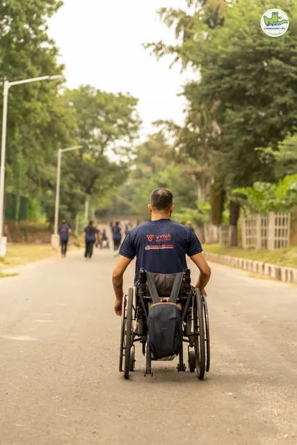 A wheelchair user on the road, seen from behind