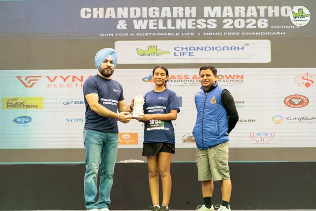 A trophy presentation on the stage in front of the event backdrop