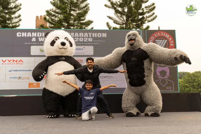 Panda and gorilla mascots posing with a child in front of the stage
