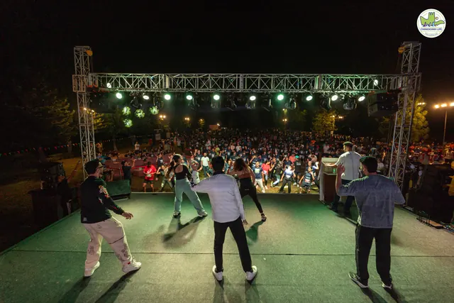 Performers on the stage at night in front of the crowd