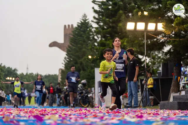 A child in a yellow T-shirt finishing on the blue carpet