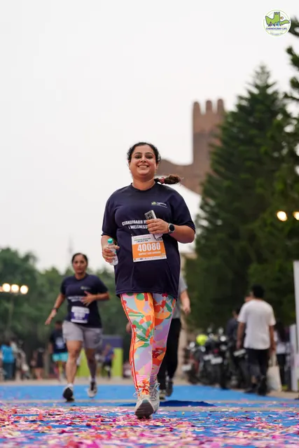 A woman finishing with the Open Hand Monument behind her