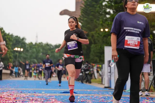 Runners crossing the finish line on the petal-covered carpet