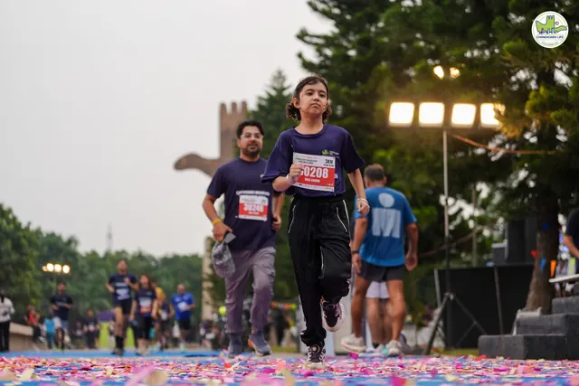 A boy running to the finish with a man beside him