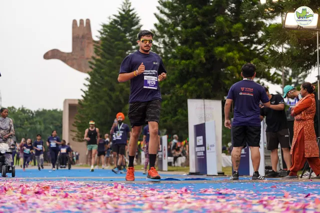 A man finishing with the Open Hand Monument behind him