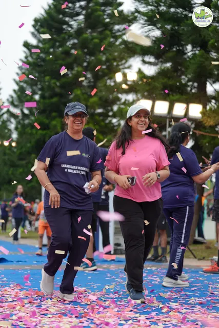 Three participants finishing together, one in a pink T-shirt