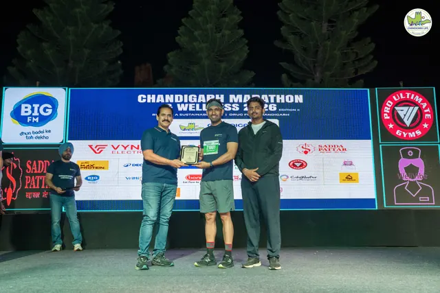 A trophy presentation on the stage with the event backdrop
