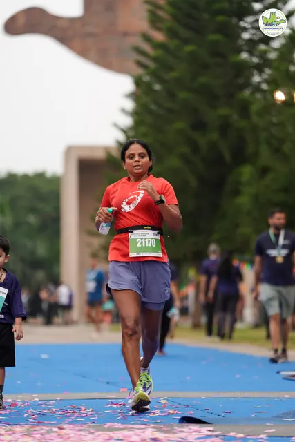 A woman in red finishing on the blue carpet