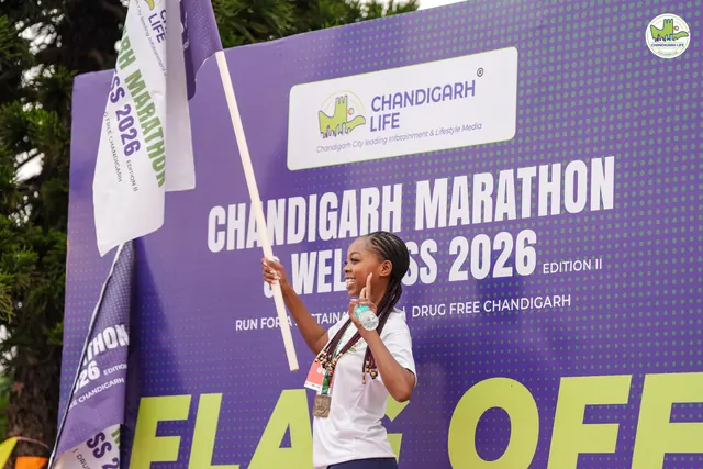 A woman with a trophy in front of the Flag Off board