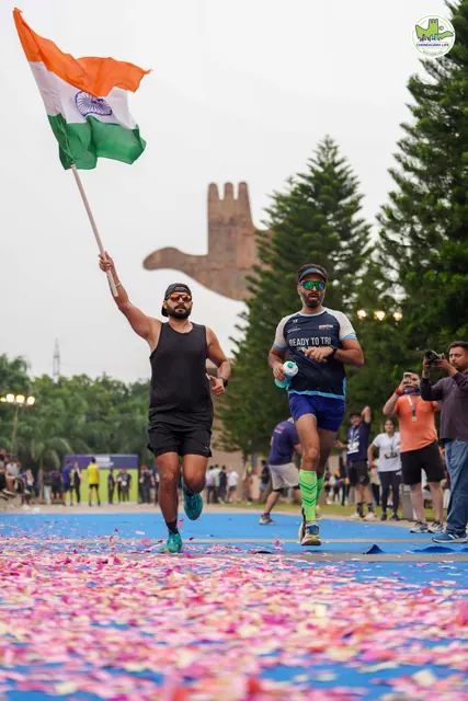 A runner carrying the Indian flag to the finish
