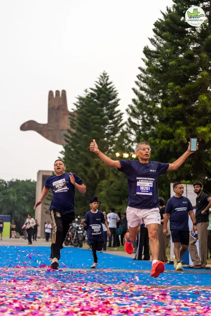 A man with arms outstretched crossing the finish