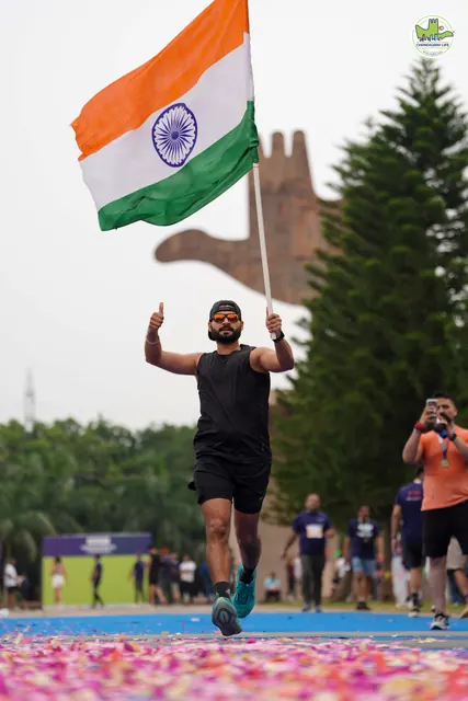 A runner with the Indian tricolour on the finish carpet