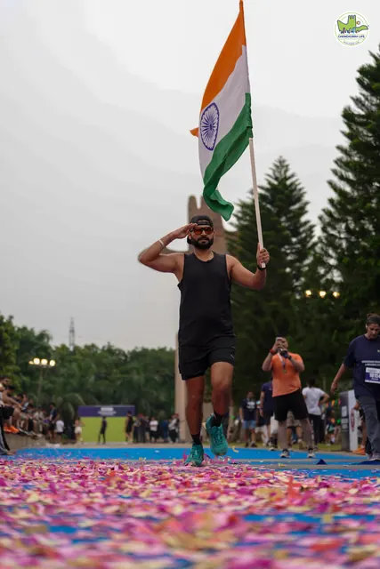 A runner carrying the Indian flag near the finish