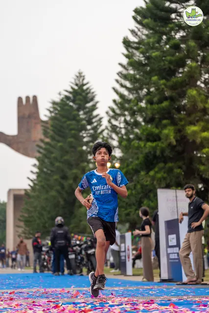 A boy in blue finishing on the blue carpet