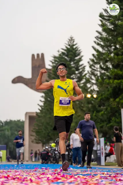A man in yellow with a fist raised at the finish