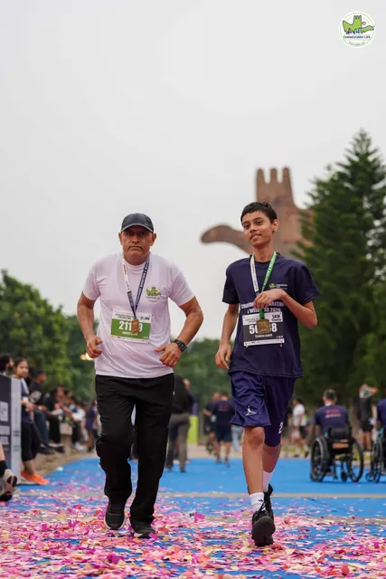 A man and a boy with a medal at the finish