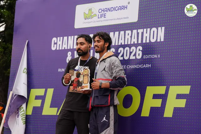 Two men with trophies in front of the Flag Off board