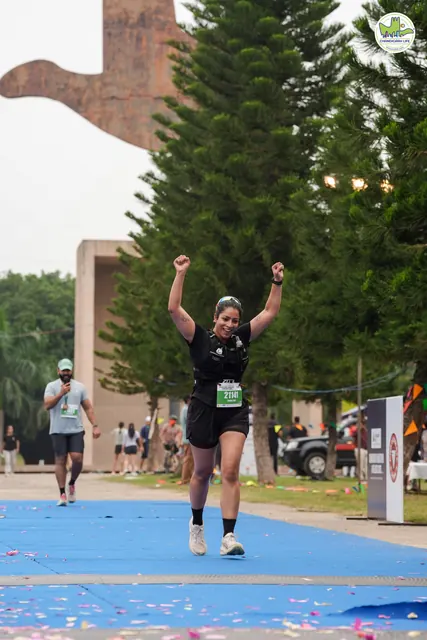A woman with both arms up at the finish