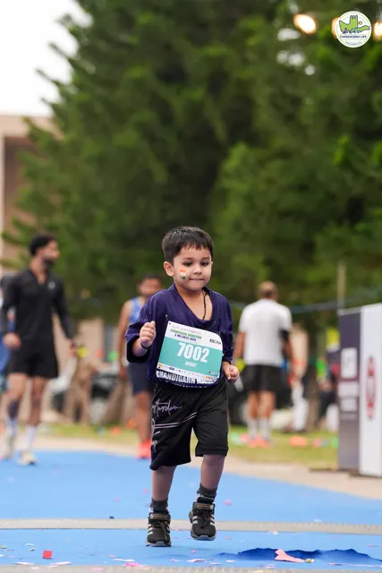 A small boy running to the finish