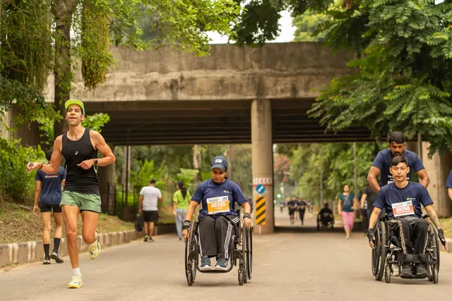 Wheelchair racers passing under an underpass with runners