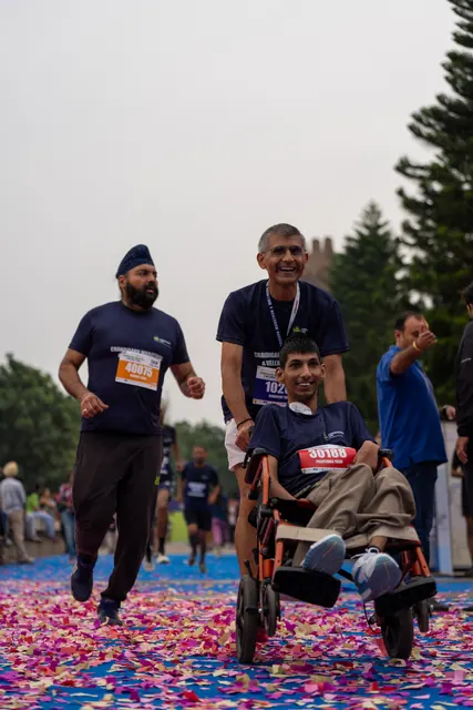 A man pushing a wheelchair user to the finish