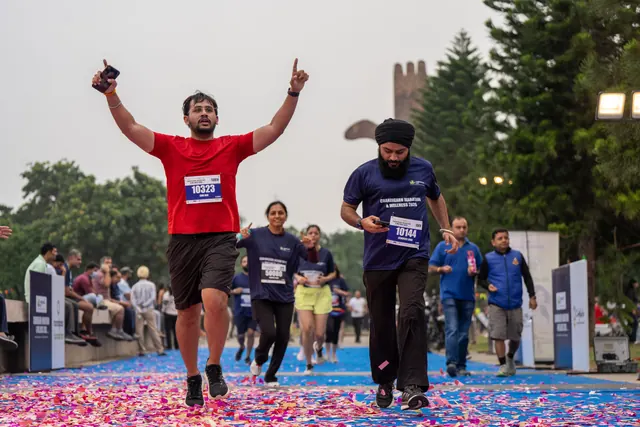 Two men with arms up crossing the finish