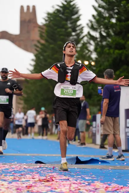 A young man with arms spread at the finish