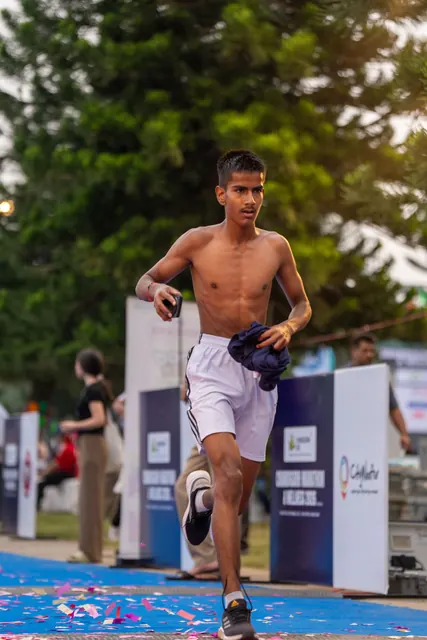 A young runner finishing on the blue carpet