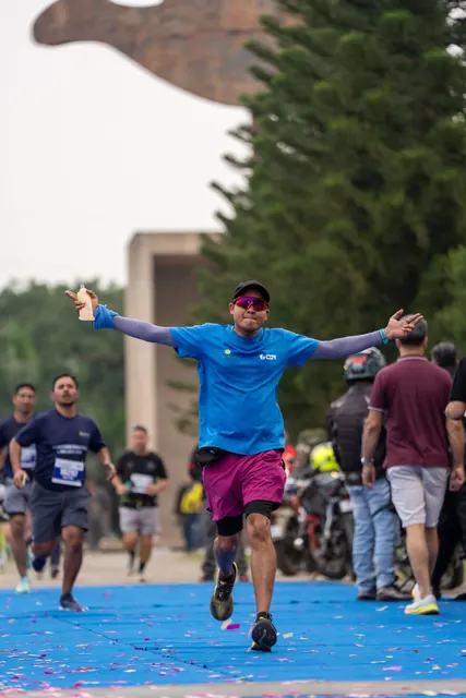 A man with arms spread at the finish