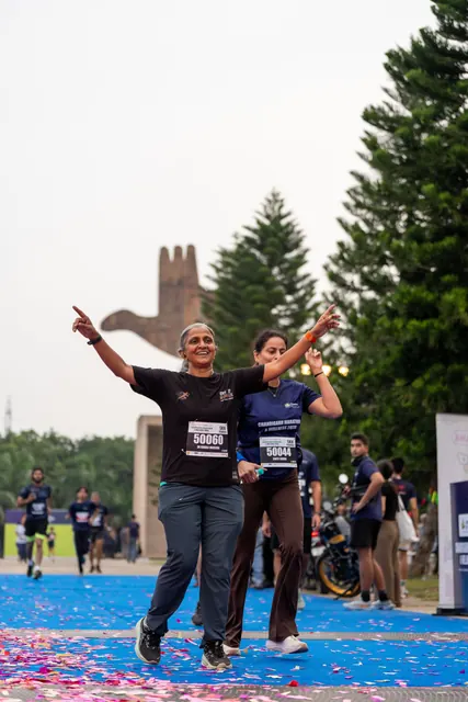 A woman pointing skywards at the finish with a child beside her